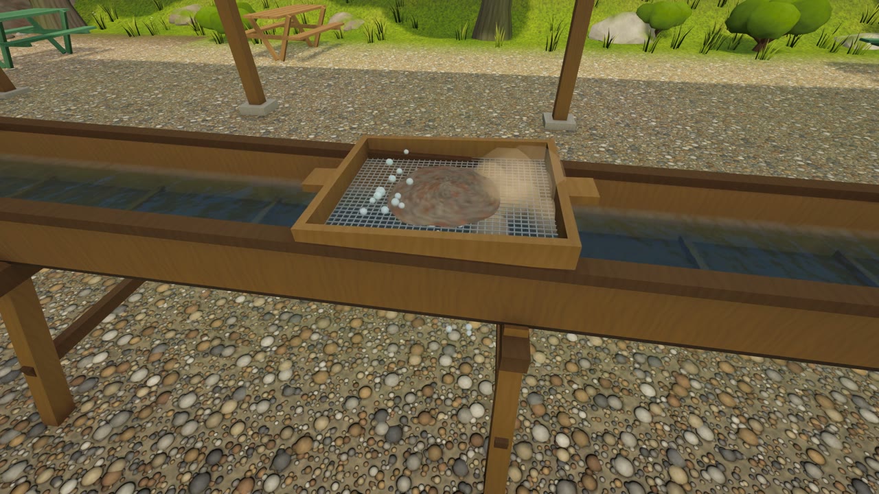 A screen of gravel being washed on a wooden flume at the gem mine